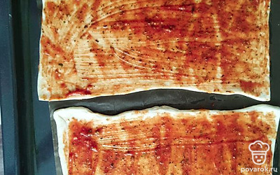 Смажьте томатной пастой пласты теста. 