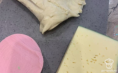 Разморозить тесто, раскатать. Подготовить любую начинку, у меня колбаса и сыр.