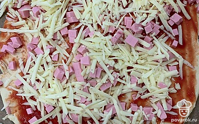 Колбасу нарезать кубиками, сыр натереть на терке, выложить на тесто.