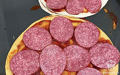 Смазываем его кетчупом и кладем колбасу.