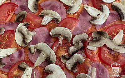 Сверху на пиццу выложить грибы.