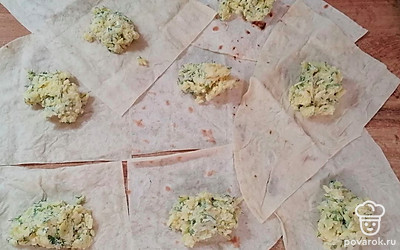 Листы лаваша разрежьте на 4 части. Итого получается 8 кусочков лаваша. Распределите начинку одинаково на все кусочки.