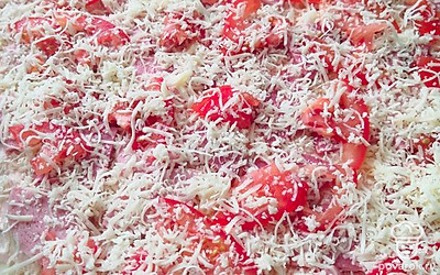 Выложить немного сыра, колбасу, помидоры и посыпать сверху оставшимся сыром.