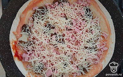 Сверху присыпать пиццу тёртым сыром, выложить на сухую разогретую сковороду.