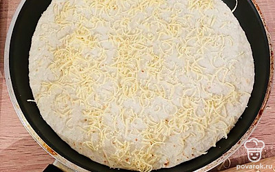 Равномерно распределить немного сыра на лепешке.