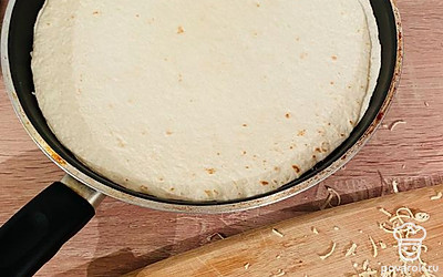 Сверху выложить ещё 1 штуку тонкой лепешки и снова посыпать сыром и уложить ещё 1 лепешку. Должно получиться всего 3 лепешки.