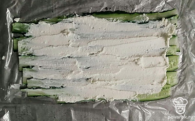 Сыр намажьте на огурцы, равномерно распределяя. 