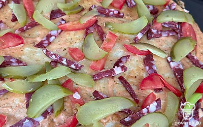 Нарезать и выложить соленый огурец.