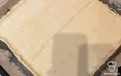 Из двух пластин готового теста слепить один пласт и раскатать его в квадратную лепешку примерно 0,5 см толщиной, выложить на противень, застеленный пергаментом. Бортики подобрать пальцами, как показано на фото.