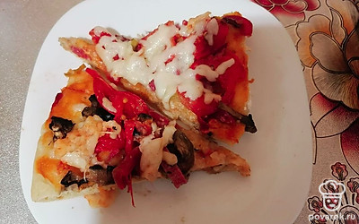 За 5 минут до готовности посыпать тертым сыром и выключить духовку, порезать пиццу на порционные куски и подавать горячей.