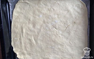 Раскатайте тесто на противень на пергаментную бумагу.