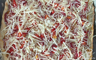 Выпекайте 10-15 минут при 200 градусах. Когда бортики пиццы подрумянятся, посыпьте сыром. Положите в духовку ещё на 3-4 минуты.