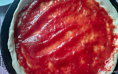 Раскатайте тесто и выложите в форму, смажьте соусом или кетчупом. Если любите поострее, добавьте перец чили или аджику.