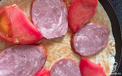 Помидор помойте. Нарежьте кусочками, разложите между ломтиками колбасы.