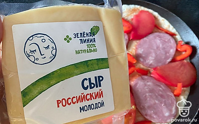 Сыр натрите на терке. Посыпьте колбасу и овощи. 