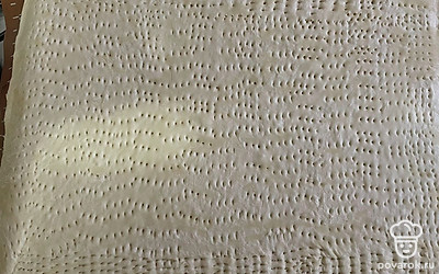 Пласт теста слегка раскатайте, наколите вилкой. Смажьте оливковым маслом и томатной пастой.