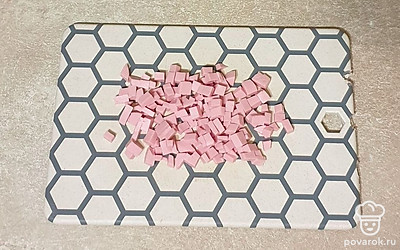 Колбасу нарежьте мелкими кубиками.