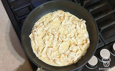 В миску к яичной заливке добавьте нарезанный лаваш, перемешайте. На разогретую сковороду вылейте основу из лаваша.