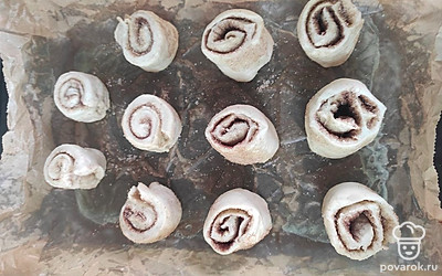 На подготовленный противень выложите булочки. Смажьте желтком и отправьте в духовку.