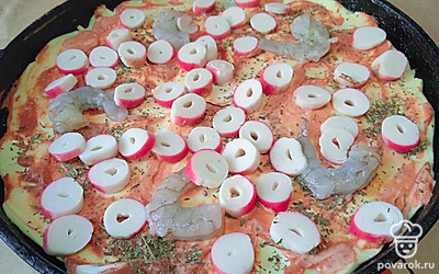 Выложите нарезанные крабовые палочки.