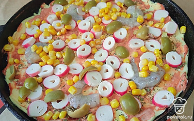 Выложите нарезанные оливки.