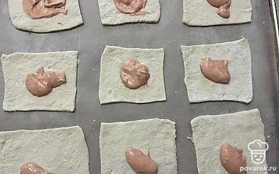 На каждую часть теста выложите небольшое количество соуса. 