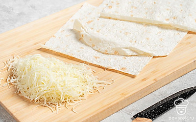 Сыр натрите на мелкой или средней терке. Лаваш разделите на три равных порции. 