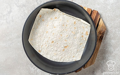 Сковороду без масла поместите на небольшой огонь. Дождитесь, когда она нагреется, а затем выложите первый лаваш.