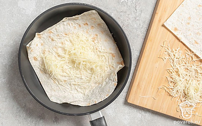 Посыпьте его небольшим количеством сыра и накройте следующим лавашом. Снова посыпьте немного сыра, а после выложите еще один лаваш. 