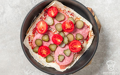 Посыпьте пиццу сыром, а затем выложите начинку в любом удобном для вас порядке.