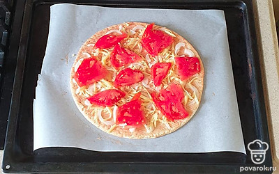 Основу для пиццы выложите на противень, застеленный пергаментной бумагой. Основу смажьте кетчупом и майонезом. Сверху выложите лук и слегка посыпьте сыром. Поверх выложите дольки помидора.