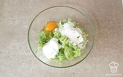 Кабачок выложите в глубокую миску. Добавьте яйцо, перец, сметану, муку и чеснок. Хорошо все перемешайте.