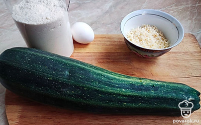 Почистите кабачок, натрите на мелкой терке или пропустите через мясорубку. Хорошенько отожмите. Разогрейте духовку до 200 градусов (режим «Верх-низ»).