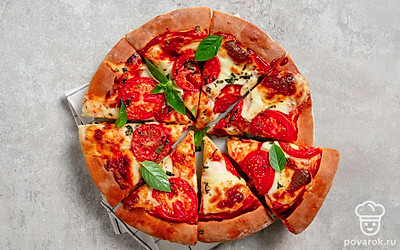 Подавайте пиццу горячей, сбрызнув ее оливковым маслом и украсив листиками базилика. 