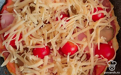 Выложить любимую начинку (мясную, грибную или с морепродуктами), помидоры, маринованный огурчик, сладкий перец. Посыпать тертым сыром.