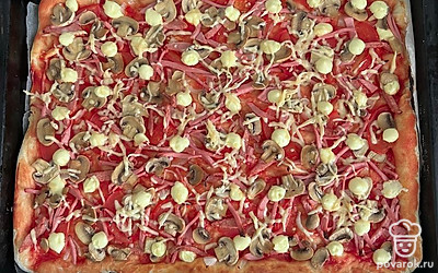 За 5 минут до готовности посыпать пиццу тертым сыром.