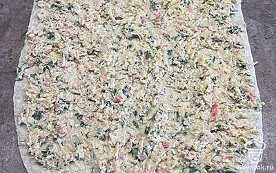 На лаваш выложите начинку и сверните в плотный рулет.