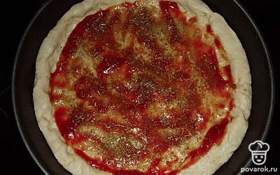 Тесто распределить по форме равномерно. Приправить томатной пастой и специями — укропом, петрушкой и паприкой.