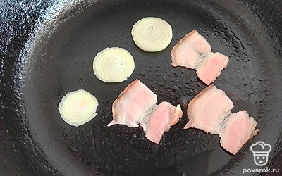 Обжарьте грудинку и лук на сковороде.