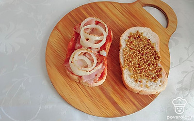 На батон выложите грудинку и лук.