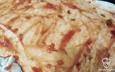 Печку предварительно разогреть до 200 градусов вместе с противнем. Смазать противень растительным масло или же постелить пергаментную бумагу, тогда его разогревать не нужно. Раскатать тесто и распределить его по всей площади формы, смазать кетчупом.