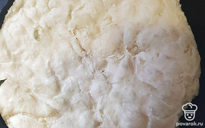 Лопаткой распределить тесто на предварительно смазанной маслом сковороде, формируя ровную поврхность. 