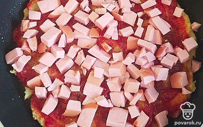 Подготовить сыр, натереть на терке и порезать колбасу. Через 10 минут корж хорошо поднимется и наполовину приготовится. Открыть крышку и распределить колбасу и сыр. Также можно полить оливковым маслом, что придаст отличный аромат. Можно добавить любую начинку по желанию.