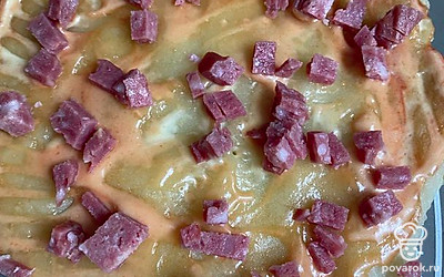 Нарезать квадратиками колбасу.