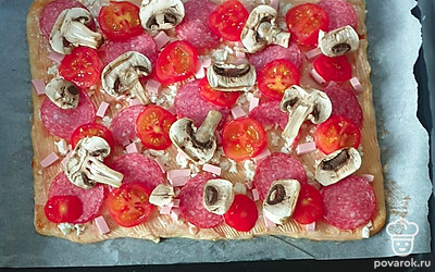 На тесто выложите все ингредиенты и выпекайте при 200 градусах в режиме «верх-низ» 20 минут.