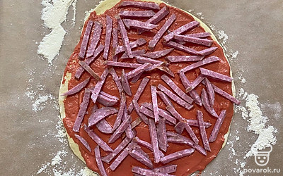 Нарезанную колбасу выложите поверх соуса.