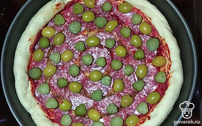 Выложить оливки и огурцы.