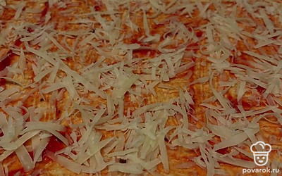 Придайте форму прямоугольника слоеному тесту и выложите на противень. На подготовленное тесто добавьте томатный соус, сыр пармезан и поставьте в духовку на 15 минут, предварительно разогретую до 200 градусов.