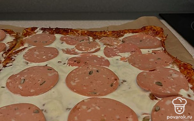 Далее достаньте подготовленную сырную лепешку, выложите страчателлу, мортаделлу и поперчите. Поставьте еще минут на 5 в духовку.