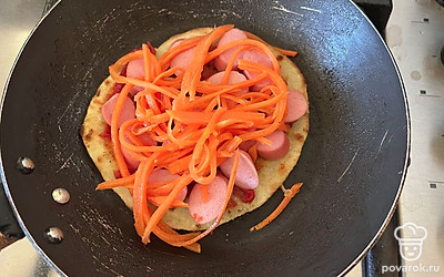 Поверх кетчупа разместите нарезанную сосиску и корейскую морковь.